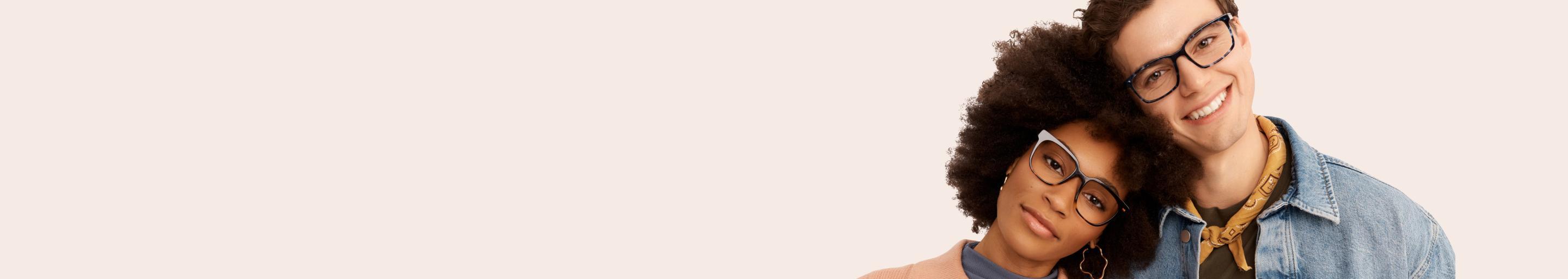 Two people standing close together with a plain background