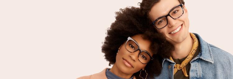 Two people wearing glasses posing together on a plain background